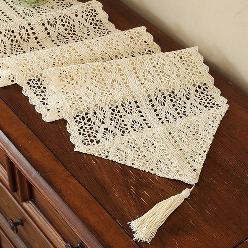Beige crochet table runner on a wooden table